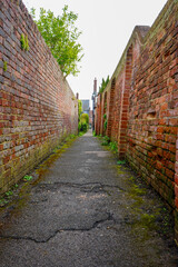Fototapeta premium View down an alleyway in with red brick walls