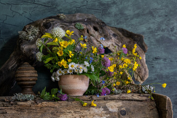 a bouquet of wild flowers in a clay pot