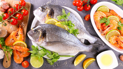 fresh fish and seafood assortment, herbs and lemon- top view