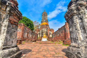 Ancient buddha statue in the middle of temple ruins in Ayutthaya, Thailand. Selective focus.