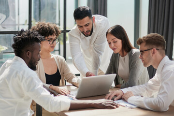 Obraz premium Employees working at computer together, discussing content