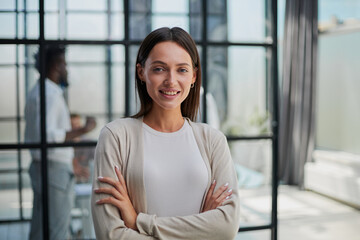 business woman with her staff in background at office