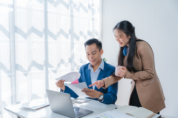 Two business people sitting at workplace and discussing about earnings on a graph to plan investments in the office room. business discussing