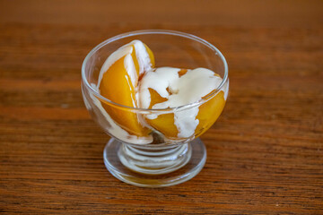 Traditional dessert of peaches in syrup with cream