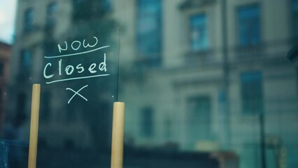 A sign in a shop window says the business is closed, informing the community about the shutdown