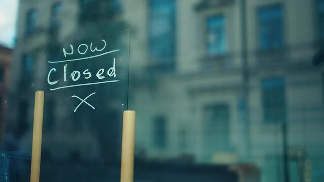 A sign in a shop window says the business is closed, informing the community about the shutdown