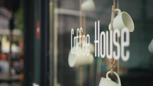 Modern coffee house has a stylish exterior with hanging mugs, creating a chic ambiance