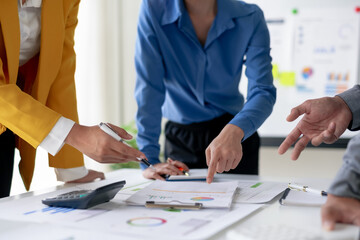 Team brainstorming session with documents and graphs on the table, focusing on business strategy...