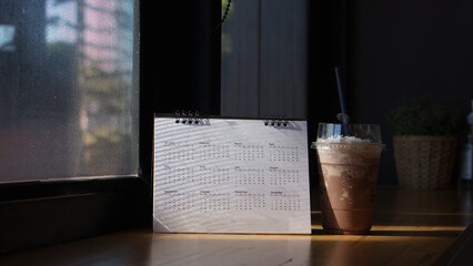 Calendar desk and iced coffee placed on business table. Desktop Calender for Planner to plan...