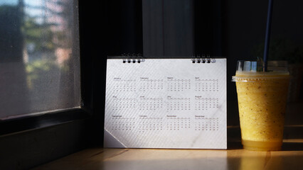 Calendar desk and iced coffee placed on business table. Desktop Calender for Planner to plan...