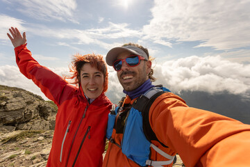 A man and a woman are posing for a picture on a mountain