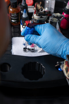 Close-up of tattoo artist's hands preparing ink in Ecuador