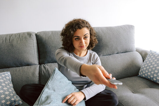 Woman relaxing on sofa with remote control