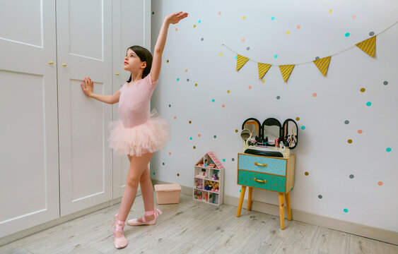 Young ballerina practices dance moves in bedroom