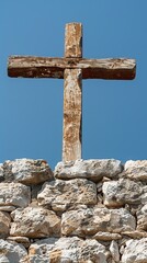 A wooden cross is positioned on a stone wall