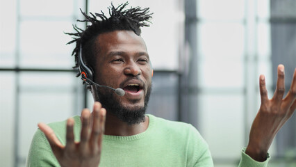 Naklejka premium Smiling friendly handsome young male call centre operator.