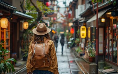 Fototapeta premium A woman with a backpack walking down a street in the old town