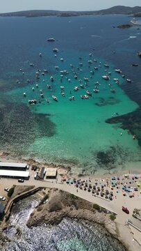 Playa illetas with clear turquoise waters and sunbathers on the beach, mallorca, spain, aerial view