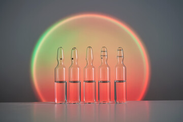 Ampoules for injection against the background of a bright orange circle.