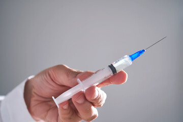 The doctor holds a syringe with medicine. Close-up.