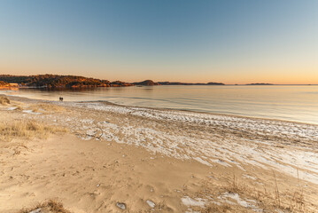 Golden glow after a sunset over an icy sand beach.