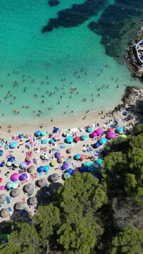Playa illetas with clear turquoise waters and sunbathers on the beach, mallorca, spain, aerial view