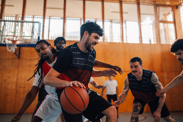 Interracial male basketball player dribbling the ball while playing the game