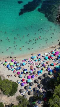 Playa illetas with clear turquoise waters and sunbathers on the beach, mallorca, spain, aerial view