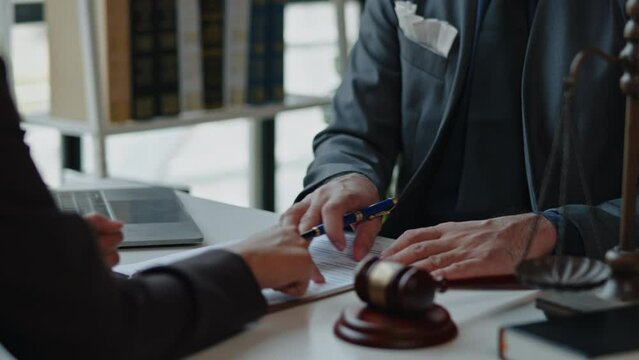Lawyers explain and discuss matters of law and contract to clients and gavel hammer.
