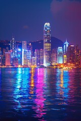 Fototapeta premium A bustling city harbor at night, panoramic view with illuminated skyscrapers, colorful reflections on the water