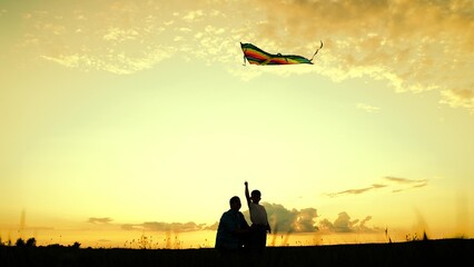Father, son play with kite in meadow. Family walk, children's dream of fly high in sky. Happy...