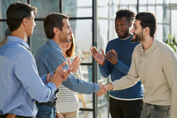 Shot of a happy businessman welcoming his new colleague to the team during a meeting in the boardroom.