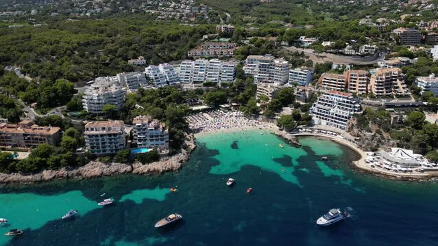 Playa illetas with clear turquoise waters and sunbathers on the beach, mallorca, spain, aerial view