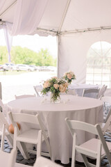 A wedding reception table decorated with a simple a flower arrangement 