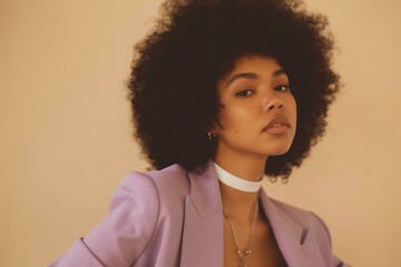 young Black woman with an afro looking to the side, wearing a lavender blazer and white top, beige background