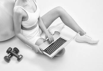 Slender dark-skinned female blogger in a white tracksuit against a white background. Healthy lifestyle, sports and diet.