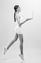 Slender dark-skinned female blogger in a white tracksuit against a white background. Healthy lifestyle, sports and diet.