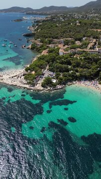 Playa illetas with clear turquoise waters and sunbathers on the beach, mallorca, spain, aerial view