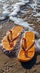 Naklejka premium A pair of bright orange sandals rest on top of a sandy beach