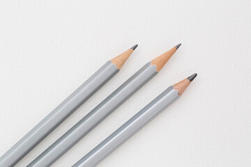 three crayon pencils laying on white sheet of paper
