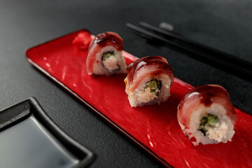 Japanese food: sushi, roll with tuna, tiger shrimp, unagi, Philadelphia. Black background