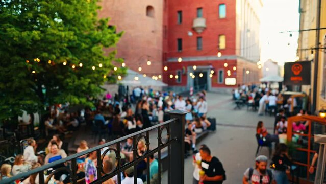 In a lively city, people dine at an outdoor cafe, socializing and relaxing in a festive atmosphere