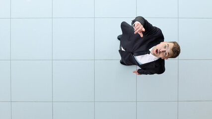 Celebrating success. Low angle view of excited young businessman keeping arms