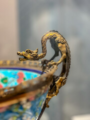 A metal dragon on the edge of the bowl.