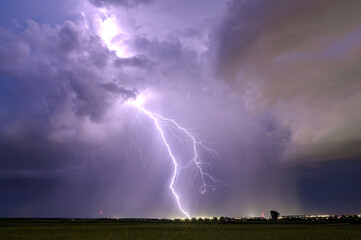 A huge storm cloud with a wall of rain in the countryside.	