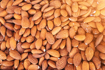 background with orange peeled almond kernels on the market counter close-up