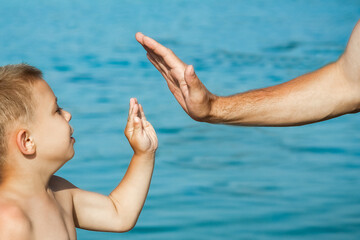 beautiful hands of parent and child by the sea