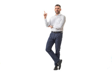 A man dressed in a white shirt and black pants poses confidently, pointing upwards with his finger, suggesting an idea or giving advice.
