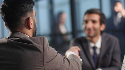 Pleasant colleagues talking at the table in the office