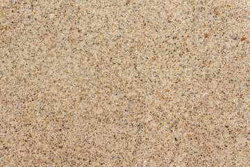 Close-up view of rough textured beige sand surface. Abstract construction material background. Soft focus. Copy space for your text or decoration. Sea travel theme.